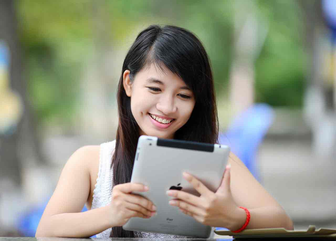 Asian girl playing on tablet