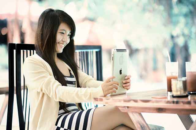 Asian girl playing on her tablet