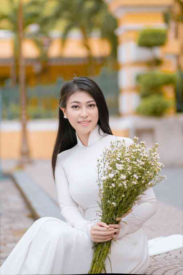 Beautiful Vietnamese girl in a white dress holding flowers